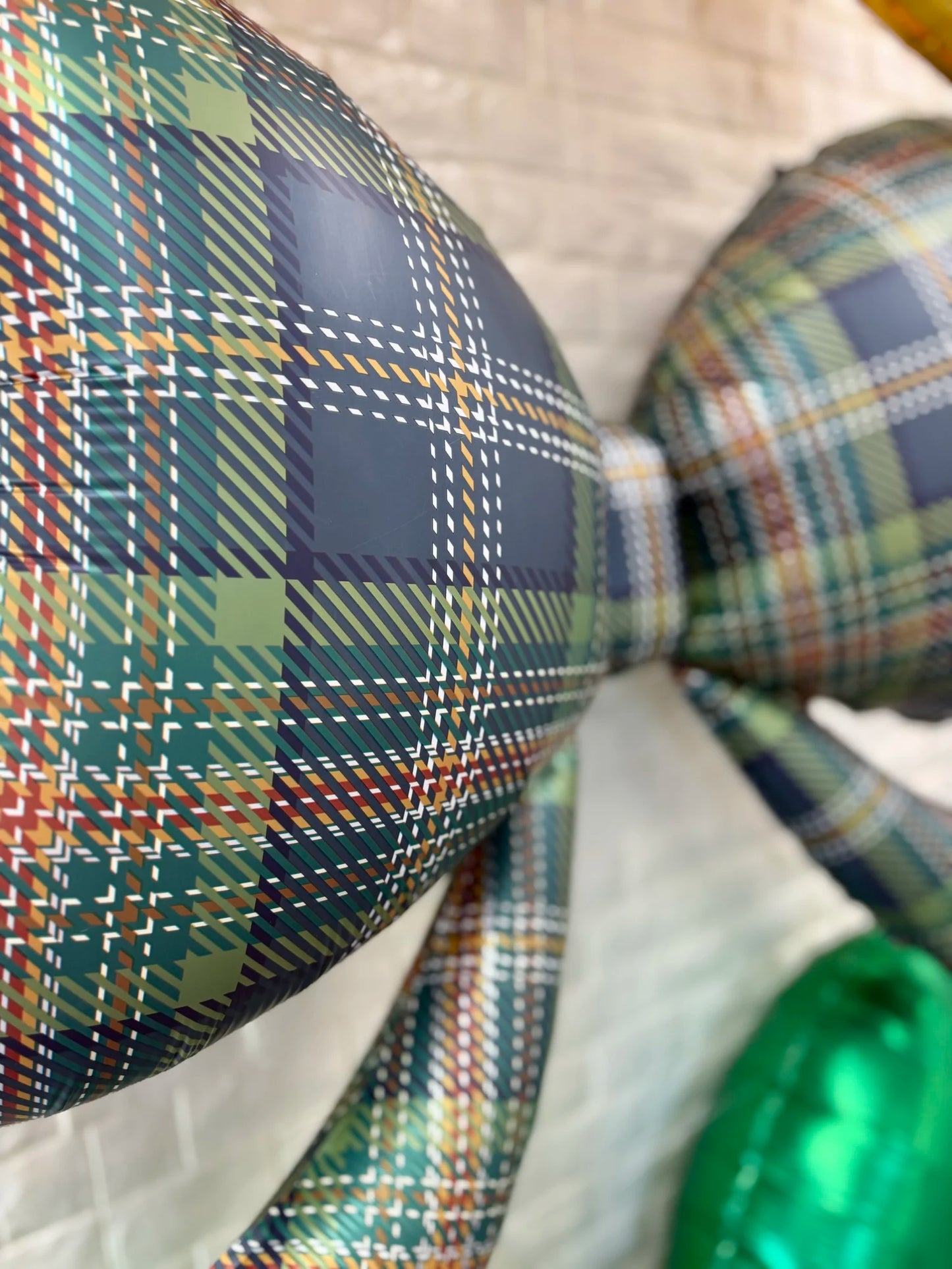 Close-up of the 40-inch plaid bow balloon showing red and black checkered pattern details